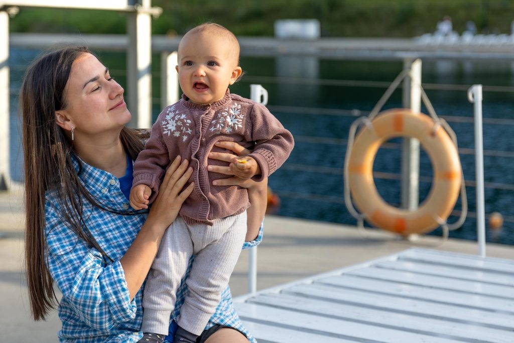 maman tenant son enfant dans les bras lors d'une sortie bateau en famille